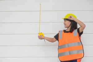 Aziatisch meisje kinderen spelen net zo een ingenieur helm foto