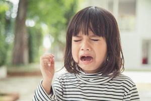 portret van Aziatisch huilen weinig meisje met weinig rollend tranen huilen emotie, pijn doen in pijn fit druppels wang. jong huilen paniek drama Aziatisch peuter. foto