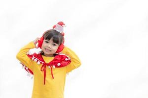 Aziatisch weinig meisje in rood de kerstman hoed Aan wit achtergrond. foto