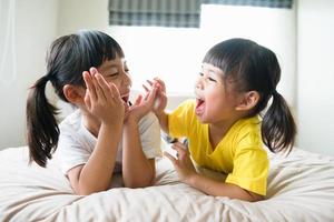 schattig Aziatisch kinderen aan het liegen Aan de bed foto