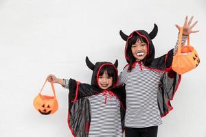 gelukkig halloween twee kinderen in halloween kostuums en met pompoenen Aan wit achtergrond foto