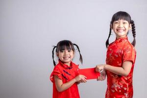 gelukkig Aziatisch weinig meisje ontvangen rood envelop voor Chinese nieuw jaar foto