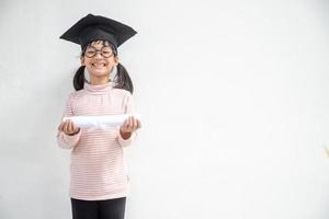 gelukkig Aziatisch school- kind afstuderen in diploma uitreiking pet foto