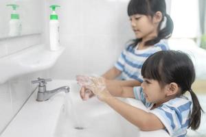 weinig Aziatisch meisjes wassen hun handen in de badkamer. zacht focus. kopiëren ruimte. foto