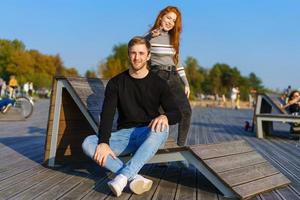 gelukkig paar vent en meisje zijn zittend Aan een houten dek knuffelen foto