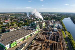 antenne visie Aan pijpen van houtbewerking onderneming fabriek zagerij. lucht verontreiniging concept. industrieel landschap milieu verontreiniging verspilling foto