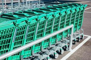 lijn van groen boodschappen doen karren in een supermarkt foto