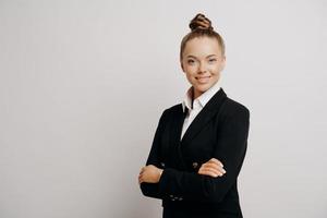 vrouw executive in donker pak staande zijwaarts foto