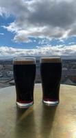 twee glas van bier met een stad visie foto