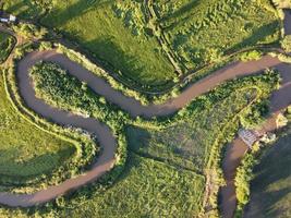 streams meander in agrarisch gebieden gedurende de regenachtig seizoen met genoeg van water. groen en warm in de ochtend- zonneschijn. foto