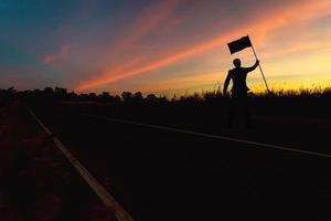 zege concept, een silhouet van een Mens staand in de zonsondergang lucht. foto