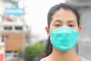 vrouw vervelend een masker naar voorkomen stof en bacterie foto