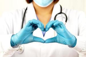 jong vrouw dokter Holding een rood hart staand Aan een wit achtergrond foto