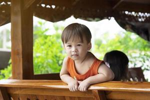 schattig weinig Aziatisch jongen is glimlachen en op zoek Bij met intentie. schattig ogen van Aziatisch kinderen. foto