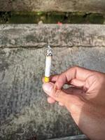 dichtbij omhoog foto van een man's Rechtsaf hand- roken een sigaret