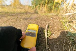 dosimeter in handen in radioactief Oppervlakte foto