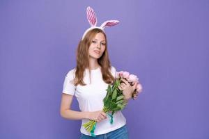 jong glimlachen vrouw in roze konijn oren Aan haar hoofd houdt boeket voorjaar foto