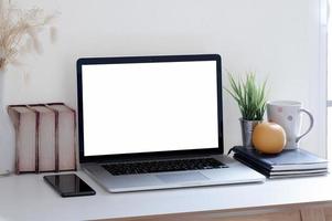 laptop mockup op een bureau met een sinaasappel en kantoorartikelen