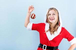 detailopname van Kaukasisch gelukkig vrouw vervelend de kerstman kleren lachend Holding Kerstmis bal foto