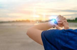 jonge aziatische vrouw die 's ochtends slimme band aanraakt na het hardlopen. draagbare computer. hartslagmeter armband. fitness apparaat. activiteits- of fitnesstracker. smartwatch aangesloten apparaat. polsbandje foto