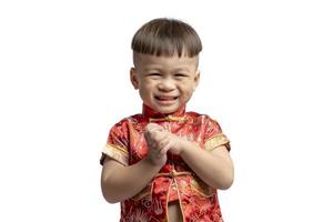 Aziatisch jongen in rood met Gefeliciteerd gebaar geïsoleerd Aan wit achtergrond. gelukkig Chinese nieuw jaar. foto