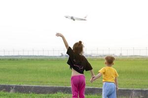 kinderen kijk maar vliegtuigen nemen uit en land- De volgende naar de luchthaven Aan weekenden. foto