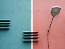 straat lamp en beton ventilatie lamellen tegen rood en blauw muur foto