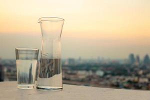 schoon drinken water voor mooi zo Gezondheid Aan de achtergrond van de zonsondergang lucht in de stad. foto