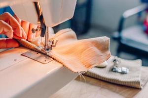 vrouwelijke handen naaien stof op machine