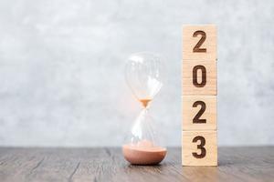 2023 blok met zandloper Aan tafel. oplossing, tijd, plan, doel, motivatie, opnieuw opstarten, countdown en nieuw jaar vakantie concepten foto