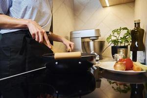 vrouw Koken saus bolognese in keuken foto