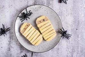 twee mummies gemaakt van geroosterd brood en kaas Aan een bord. halloween recept. top visie foto