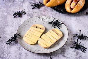 toast met kaas in de het formulier van mummies Aan een bord en spinnen. halloween recept. foto