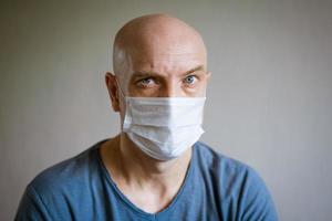 portret van een kaal Mens vervelend een beschermend masker foto