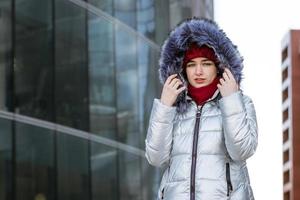 vrouw in een warm jasje Aan de straat in de buurt de gebouw foto