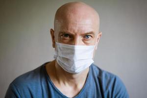 portret van een kaal Mens vervelend een beschermend masker foto