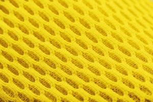 fragment van een geperforeerd teen van een geel sneaker in detailopname. foto