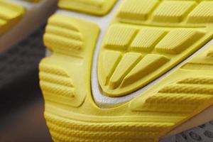 getextureerde ontwerp van de zool van de betreden van een sneaker in geel macro. foto