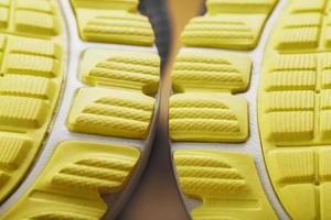 getextureerde ontwerp van de zool van de betreden van een sneaker in geel macro. foto