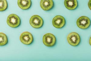 de patronen van de plakjes van kiwi fruit Aan groen achtergrond net zo een doorlopend achtergrond. foto