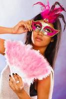 vrouw met carnaval maskers houdt ventilator foto