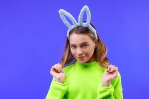jong vrouw in konijn oren Aan een blauw achtergrond foto