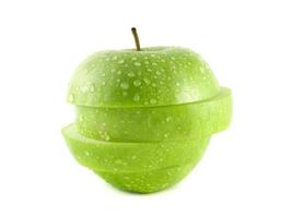 geïsoleerde groene appelschijfjes met waterdruppels foto