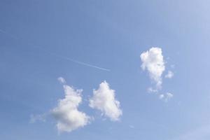 condensatiesporen van vliegtuigen in de blauwe lucht tussen enkele wolken foto