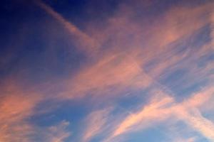 condensatiesporen van vliegtuigen in de blauwe lucht tussen enkele wolken foto