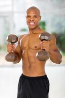 Afro-Amerikaanse man met halters in de sportschool