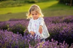 schattige babymeisje in een veld lavendel