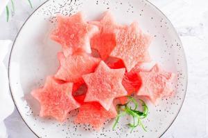 stukken van vers watermeloen in de het formulier van sterren Aan een bord. zomer verfrissing. top visie. dichtbij omhoog foto