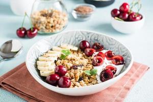 muesli met kers, banaan en vlas zaden in een kom Aan de tafel. eigengemaakt ontbijt foto