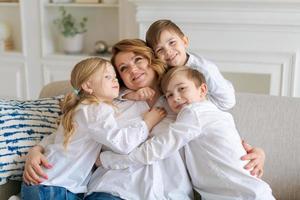 schattig kinderen knuffelen, opgewonden mam tonen liefde en affectie, glimlachen moeder foto